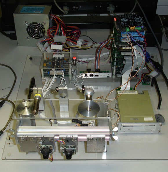 One of several benchtop systems that duplicate essential components of rover electronics for ease of testing. Shown is a PC104 computation stack (background) with controlled motors and stereo cameras (foreground).