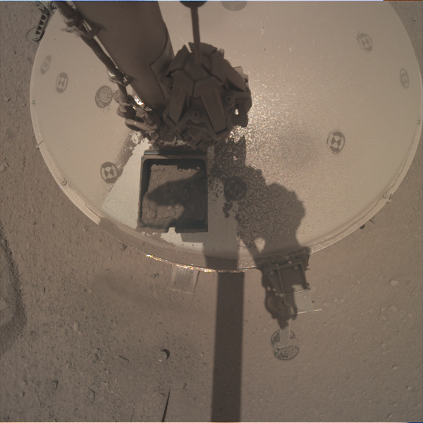 Figure 3: A view from the IDC of the IDA preparing to dump a scoopful of Martian regolith onto the SEIS tether.